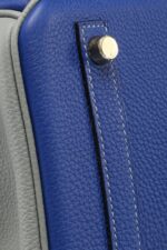 London, UK. 30th Nov, 2021. A bleu electrique Clémence leather retourné  Kelly 32, Hermès, 2014, est £7,000-9,000 with a rouge vif ostrich leather  birkin 30, Hermès, 2015, est £10,000-15,000 and a jaune